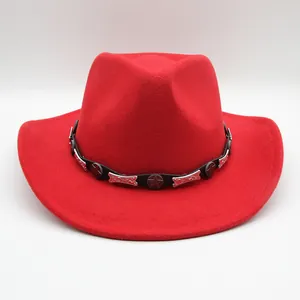 Détail d'un chapeau de cow-boy en feutre rouge avec ceinture en cuir et boucle étoile