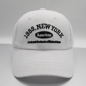 Detailed view of white cotton baseball cap featuring 1989 New York black embroidery