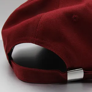 Macro shot of high-density cotton twill fabric and stitching on wine red baseball cap