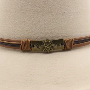 Close-up of beige wool fedora featuring a bronze skull emblem and braided leather band