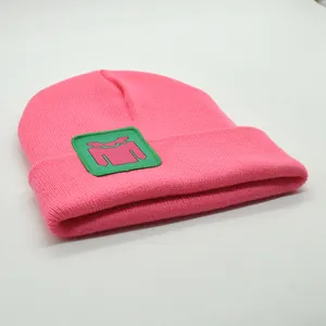 Detailaufnahme der rosa Strickmütze mit grünem Aufnäher und Rippstrick-Textur