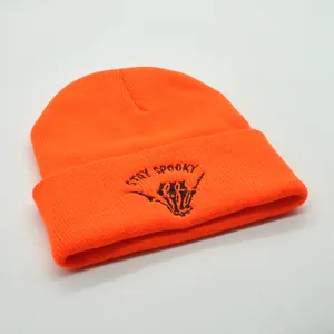Bright orange knit beanie featuring black Stay Spooky skull hand embroidery for Halloween