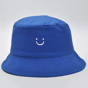 Dettaglio cappello a secchiello blu reale con ricamo smiley bianco in cotone canvas