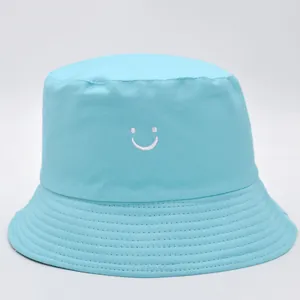 Dettaglio del cappello alla pescatora celeste con ricamo a forma di smiley sul davanti