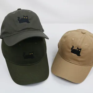 Dettaglio del ricamo gatto nero con occhi gialli su cappellini da baseball in cotone