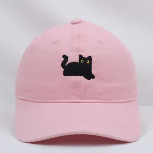 Dettaglio del ricamo a gatto nero su un cappellino da baseball in cotone rosa pastello