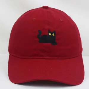 Dettaglio del cappellino in cotone rosso con ricamo a gatto nero e visiera curva