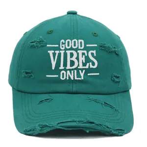 Detail of GOOD VIBES ONLY embroidery on distressed dark green cotton baseball cap