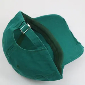 Detail of dark green baseball cap with adjustable metal buckle and distressed edges