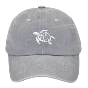 Close-up of turtle embroidery on dark gray washed cotton baseball cap with vintage texture