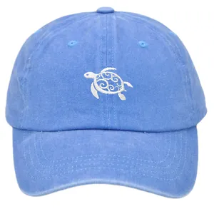 Close-up of white sea turtle embroidery on a vintage washed navy blue baseball cap