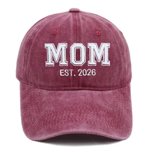 Dettaglio del ricamo 3D bianco MOM EST. 2026 su berretto in cotone lavato color bordeaux