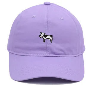 Primer plano de gorra de algodón lavanda con bordado detallado de una vaca blanca y negra