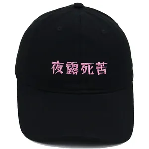 Detailed view of pink embroidery on a black cotton baseball cap with curved brim