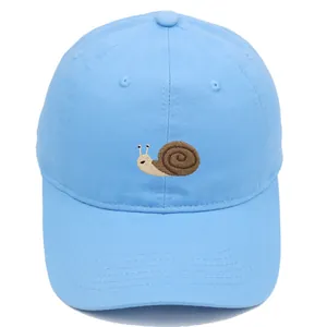 Detailed close-up of snail embroidery on a light blue cotton baseball cap with neat stitching