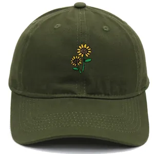 Macro detail of sunflower embroidery on an olive green washed cotton baseball cap