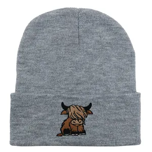 Detailed embroidery of a Highland cow on a grey knit beanie cap with folded brim