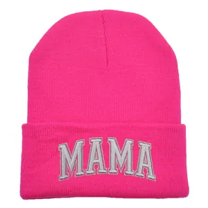 Détail de la broderie MAMA 3D sur un bonnet en maille rose vif pour l'hiver