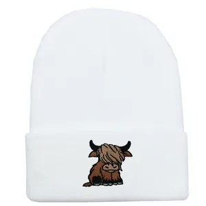 White knitted beanie with Highland Cow embroidery for winter outdoor warmth and style