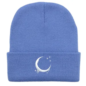 Dettaglio del berretto in maglia azzurro con ricamo bianco di luna e stelle