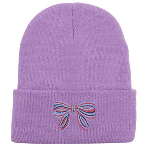 Dettaglio del berretto in maglia viola con ricamo a fiocco colorato e texture