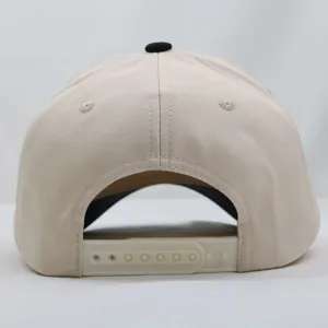 Detail view of adjustable plastic snapback closure on a beige 5-panel twill baseball cap
