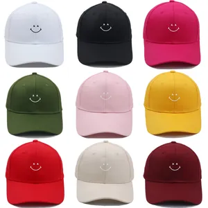 Nine-color grid of baseball caps featuring minimalist embroidered smiley faces on the front