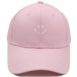 Pink cotton baseball cap featuring white embroidered smile face and structured sun visor