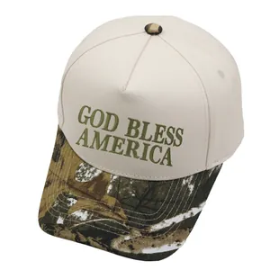 Detail of God Bless America embroidery on beige trucker hat with camouflage leaf pattern brim