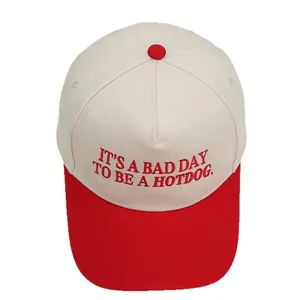 Gedetailleerde close-up van de rood-witte honkbalpet met borduursel IT'S A BAD DAY TO BE A HOTDOG