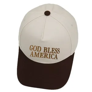 Detailed golden embroidery of GOD BLESS AMERICA text on a contrast trucker hat