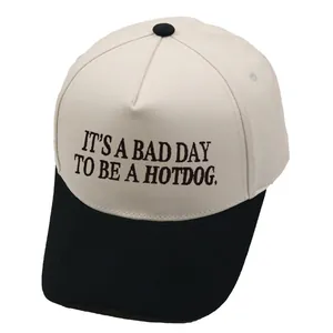 Tweekleurige baseballpet met IT'S A BAD DAY TO BE A HOTDOG borduursel in crème en zwart