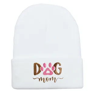 Dettaglio del berretto in maglia bianca con ricamo DOG mom e impronta di zampa rosa