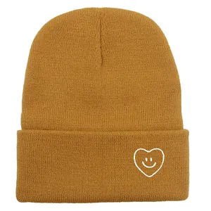 Bonnet en maille jaune gingembre avec motif visage souriant en cœur brodé