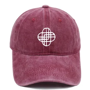Macro detail of white geometric embroidery on a vintage washed dark red baseball cap
