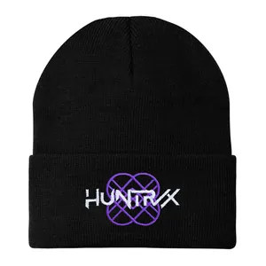 Nahaufnahme der HUNTRVX-Stickerei und des lila Musters auf der schwarzen Strickmütze