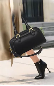 Detail of black leather bowling bag showing metal buckles and detachable shoulder strap