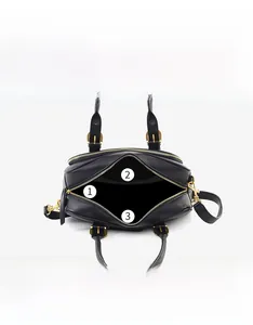 Detailed view of black leather handbag interior with gold zipper and organized pockets