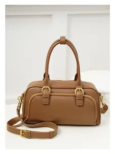 Detail view of caramel brown vintage bowling bag with gold hardware and top handles