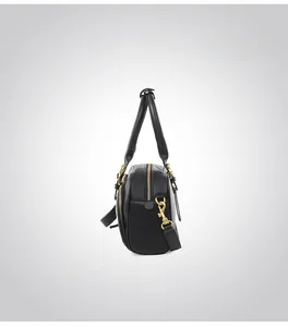 Side view of black pebble leather bowling bag with gold hardware and shoulder strap