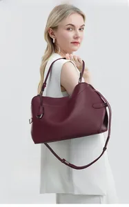 Deep burgundy leather tote bag with elegant handles and adjustable shoulder strap detail
