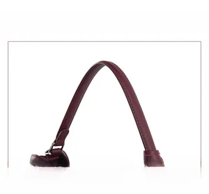 Detail of soft burgundy leather handle with reinforced stitching and metal hardware