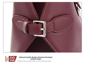 Macro shot of silver side buckle and leather texture on a burgundy shoulder bag