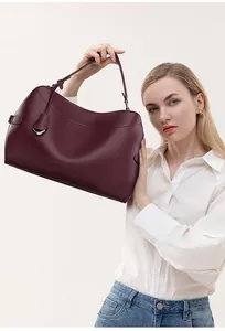 Deep burgundy leather shoulder bag detail showing fine stitching and metal ring charm
