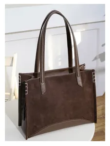 Détail du sac cabas marron foncé avec coutures contrastées blanches et aspect suède mat