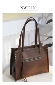 Détail d'un sac cabas marron foncé mat avec coutures blanches contrastées et poche zippée