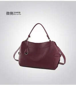 Detail of wine red leather tote bag showing side buckle and silver hardware accents
