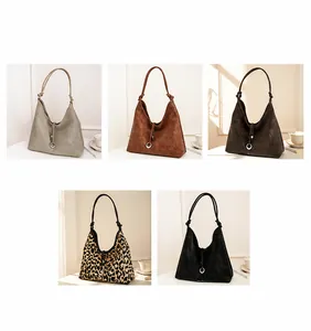 Detailoverzicht van suède shopper tassen in diverse kleuren met decoratieve schouderknopen