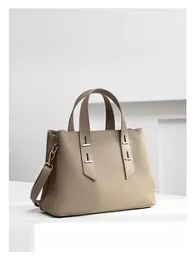 Detailed view of taupe leather tote bag with elegant handles and fine grain texture