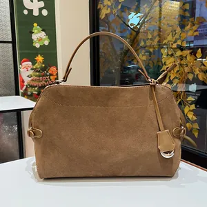 Close-up of deep brown suede tote bag with decorative stitching and metal buckle detail